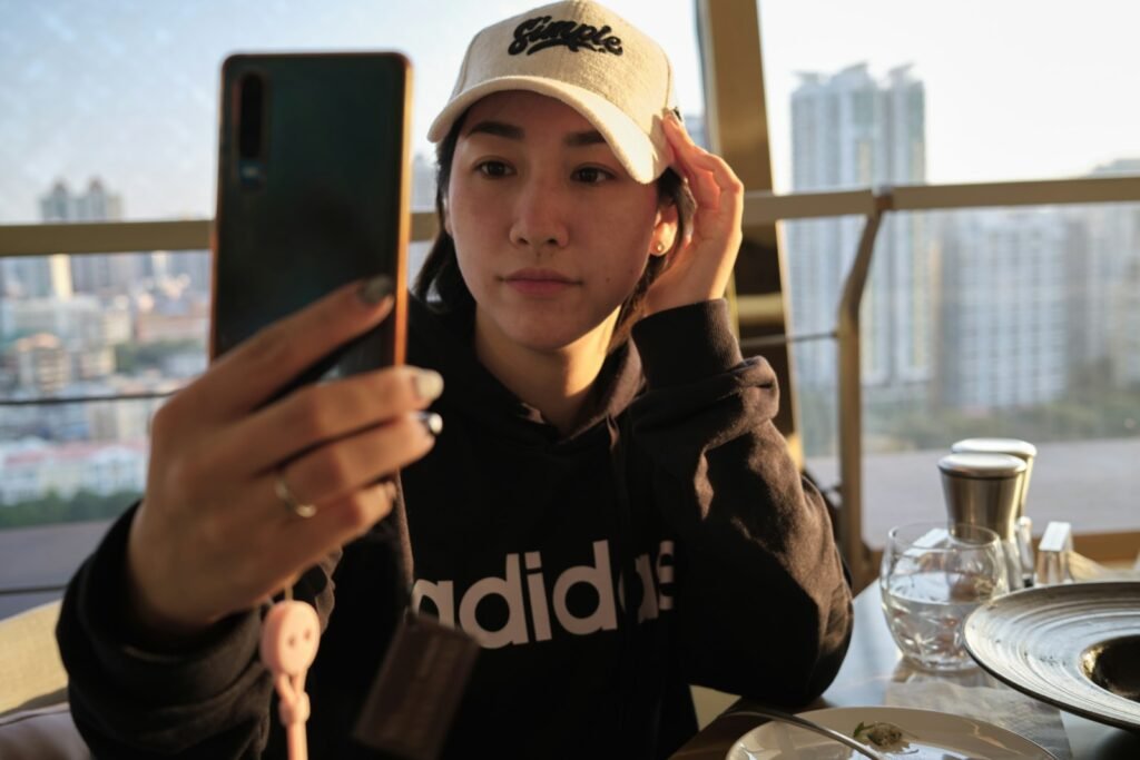 Content creator taking a selfie with a phone, representing Xiaohongshu RedNote marketing