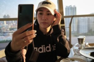 Content creator taking a selfie with a phone, representing Xiaohongshu RedNote marketing