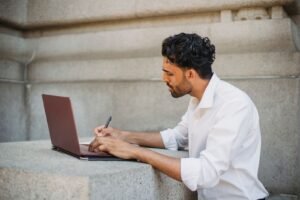A developer at a WordPress website development agency reviewing an installed plugin list and code editor across two monitors.